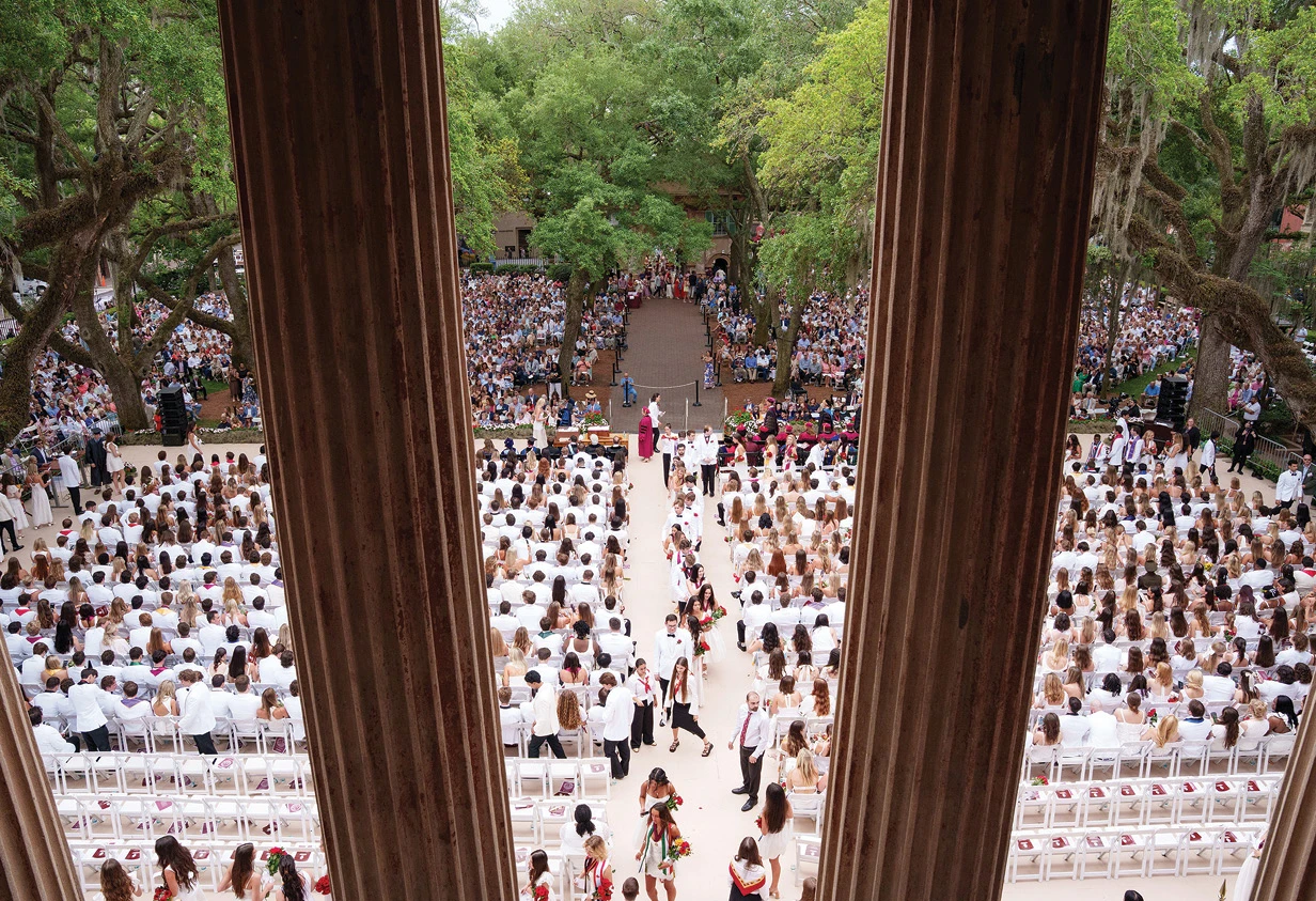Overhead view of a large outdoor commencement ceremony framed by historic columns.